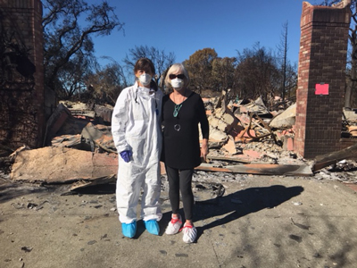 Suzanne O’Brien standing in front of what's left of her home. Survivor stories from The Great Wine Fires of 2017 as told to The Luxury Marketing Council of San Francisco